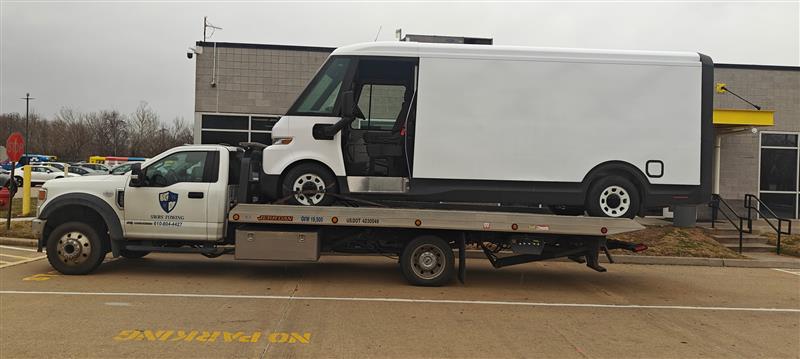 SWRS Towing flatbed rollback transporting a large commercial box truck