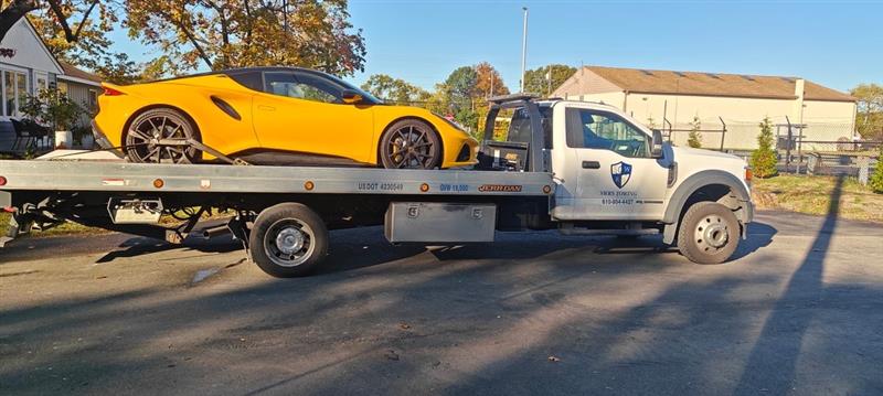 SWRS Towing flatbed carrying a yellow Corvette