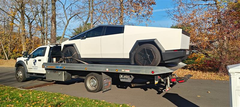 SWRS Towing flatbed transporting a Tesla Cybertruck in autumn